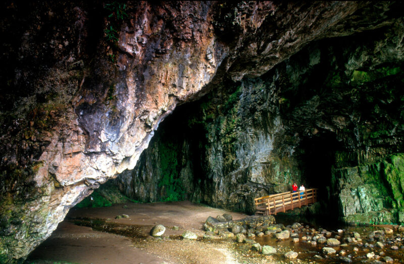 Looking Over To A Two People On The Wooden Walkway At The Entrance To Smoo Cave